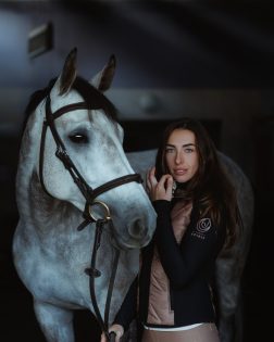 Jazdecká hybridná bunda čierno-hnedá – modelka s bielym koňom