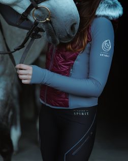 Black full-grip riding leggings – with burgundy hybrid jacket beside a horse